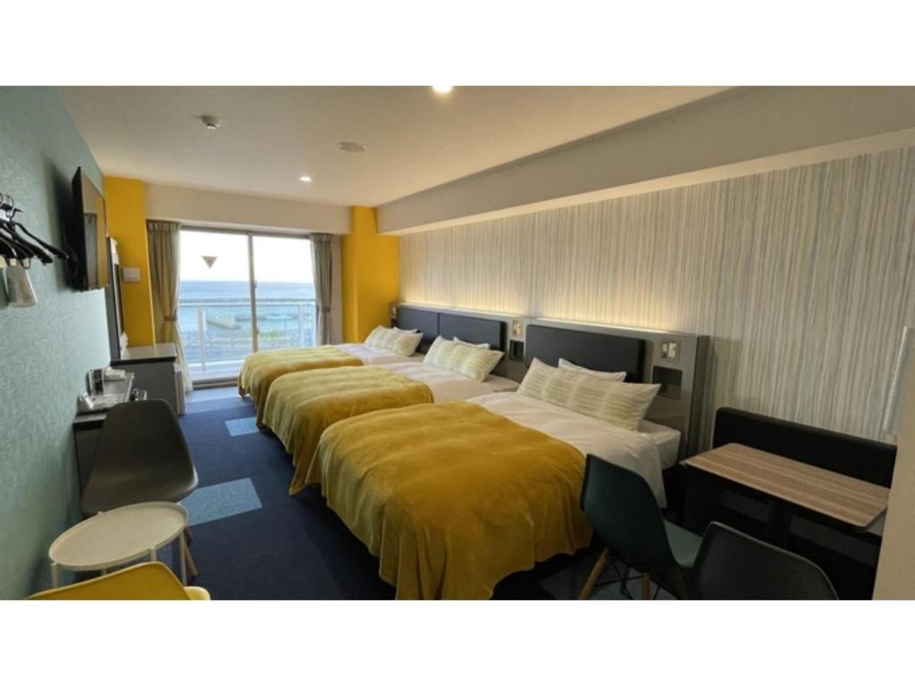 Green Rich Hotel Okinawa Nago - Vacation STAY 49879v في ناغُو: صف من الاسرة في غرفة الفندق