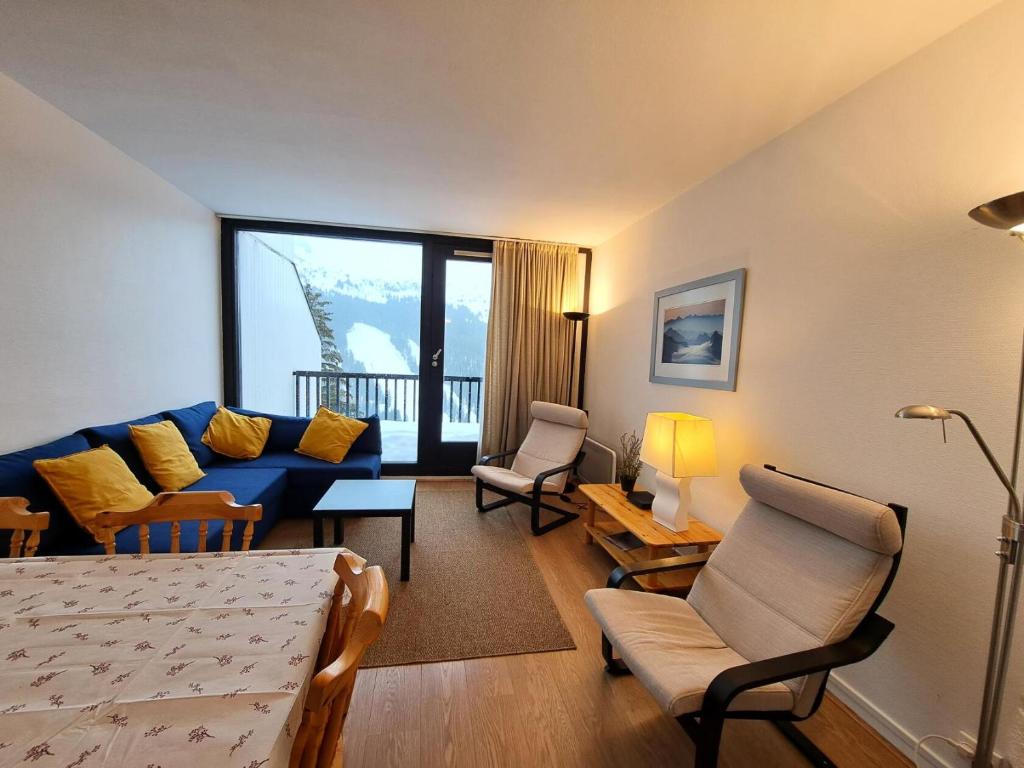 un salon avec un canapé bleu et une table dans l'établissement Résidence Capricorne - maeva Home - Appartement 2 Pièces 6 Personnes - Confort MAE-3832, à Arâches-la-Frasse