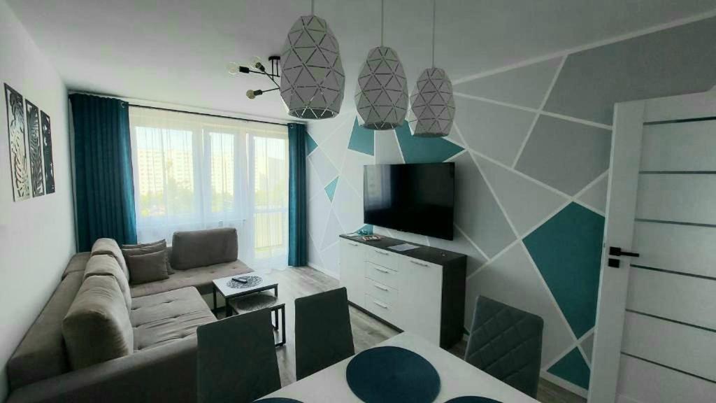 Apartament SEASIDE Gospody 5a في غدانسك: غرفة معيشة مع أريكة وتلفزيون