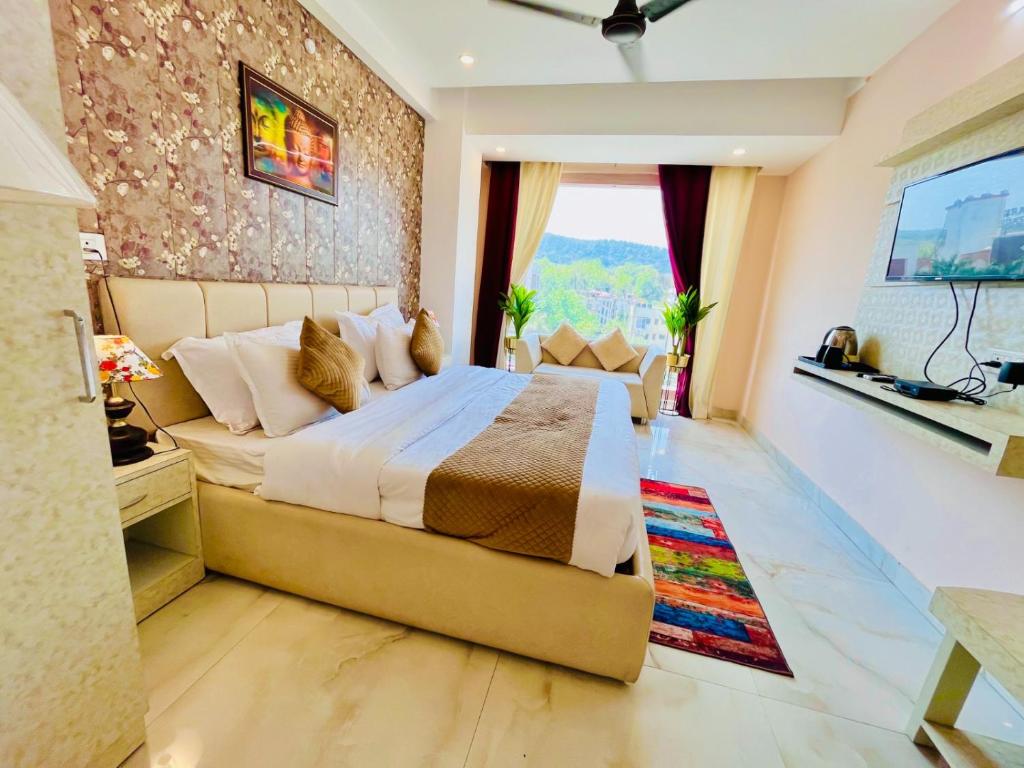 - une chambre avec un grand lit et une grande fenêtre dans l'établissement Hotel The Tirath View, à Haridwar