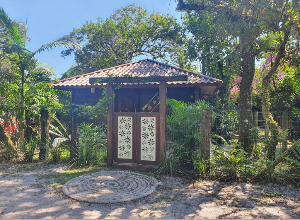 eine Holztür in einem Garten mit einem Tor in der Unterkunft Casa da Lívia - Ilha do Mel in Paranaguá