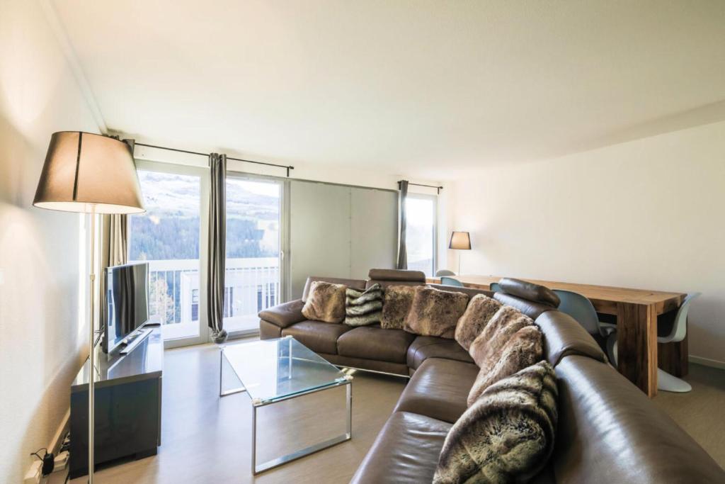 un salon avec un canapé en cuir et une table dans l'établissement Résidence La Petite Ourse - maeva Home - Appartement 4 Pièces 6 Personnes - Sélection MAE-3904, à Arâches-la-Frasse