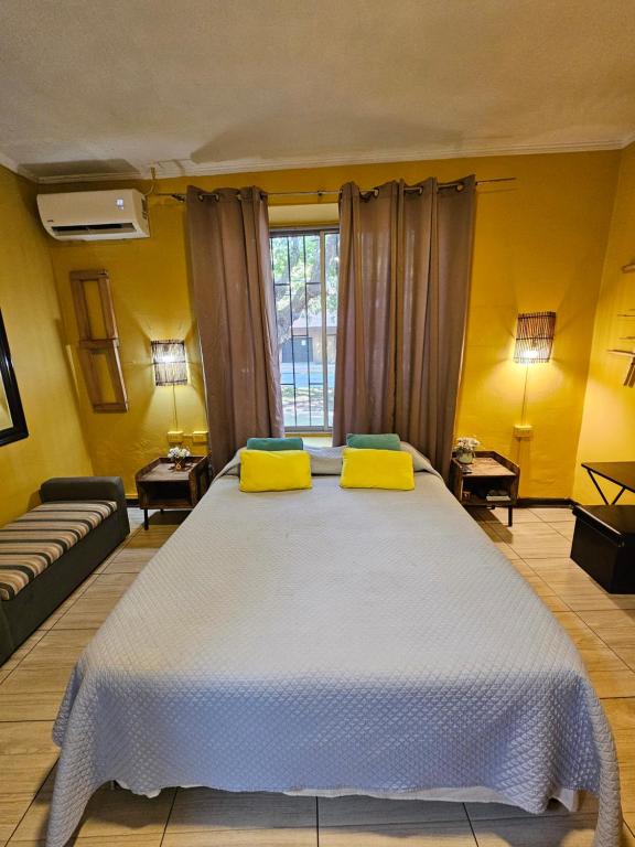 um quarto com uma cama grande e paredes amarelas em Hostal Pucara Molina em Molina