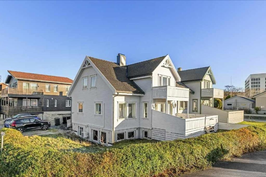 a white house with a car parked in a driveway at Novkrokene - Spacious and fully equipped 3 beds apartment with free parking in Stavanger