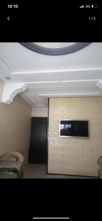a room with a white ceiling and a tv on a wall at Appartement Hay salam in Agadir