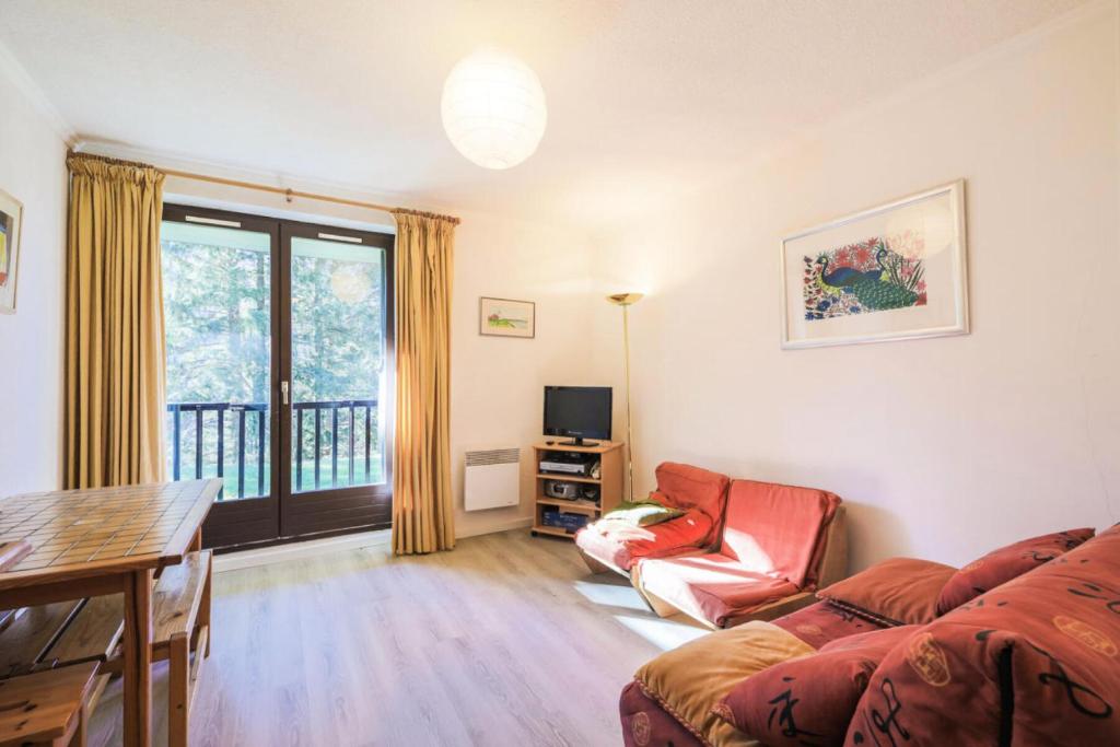 un salon avec un canapé et une table dans l'établissement Résidence Pollux - maeva Home - Studio 4 personnes - Budget MAE-4213, à Arâches-la-Frasse