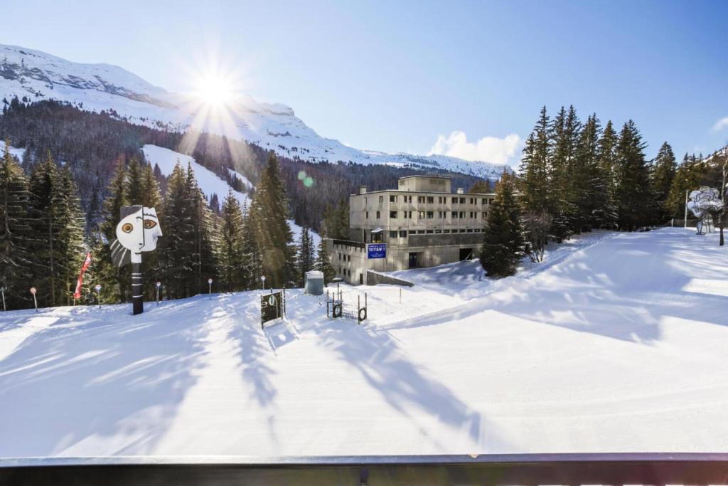 une piste de ski couverte de neige avec un bâtiment en arrière-plan dans l'établissement Résidence Aldébaran - maeva Home - Appartement 3 Pièces 8 Personnes - Confort MAE-4231, à Arâches-la-Frasse