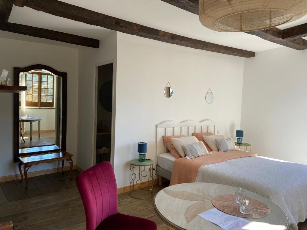 sypialnia z łóżkiem, stołem i krzesłami w obiekcie LA CONQUISE w mieście Conques-en-Rouergue