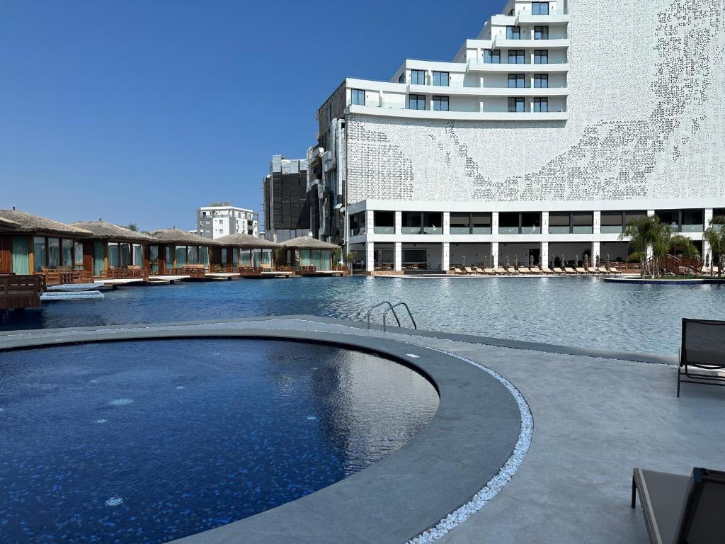 a large swimming pool in front of a building at Grand Sapphire Resort 1+1 İskele in Iskele