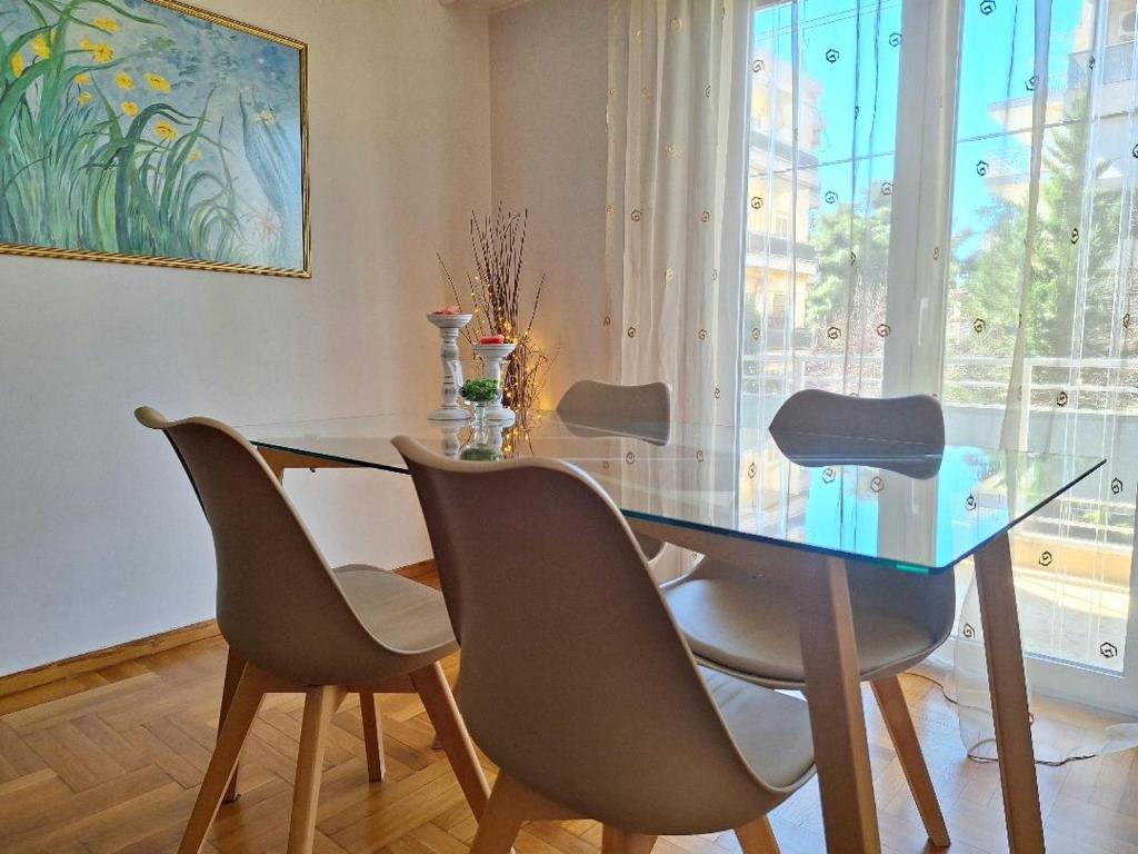 a dining room with a glass table and chairs at Cozy apartment next to metro station in Athens