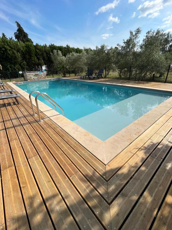 einen großen Pool mit Holzterrasse in der Unterkunft Gîte en Provence in Monteux