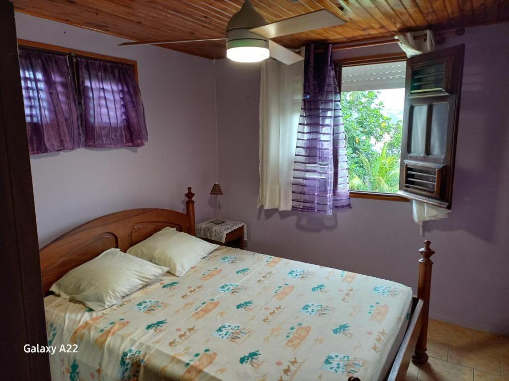 - une chambre avec un lit et une fenêtre dans l'établissement Le petit coin tranquille, à La Trinité