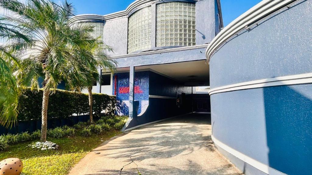 un edificio azul con una palmera delante de él en Motel Fashion ABC, en Santo André