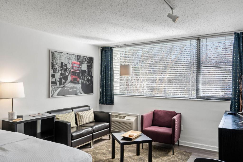 a hotel room with a bed and a couch and chairs at Studios On 25th by BCA Furnished Apartments in Atlanta
