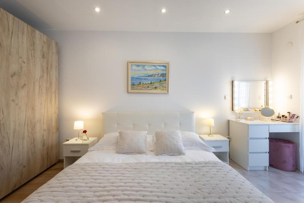 - une chambre avec un grand lit blanc et 2 tables de chevet dans l'établissement Florami Apartment, à Kaštela
