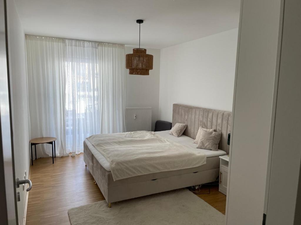 ミュンヘンにあるFerienwohnung mit Innenstadtanbindungの白い部屋のベッドルーム1室(ベッド1台付)