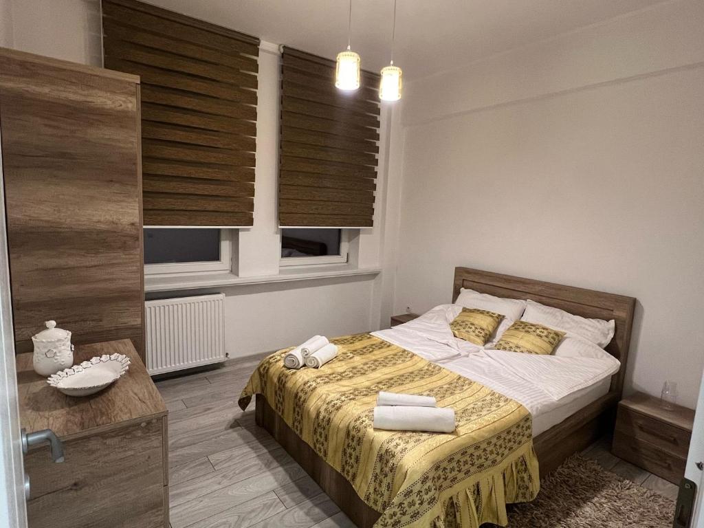 1 dormitorio con 1 cama con manta amarilla en Apartament Claudia en Baia Mare