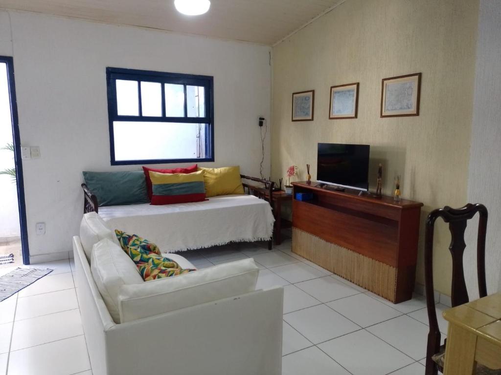 a living room with a bed and a television at Apartamento no Centro de Búzios in Búzios
