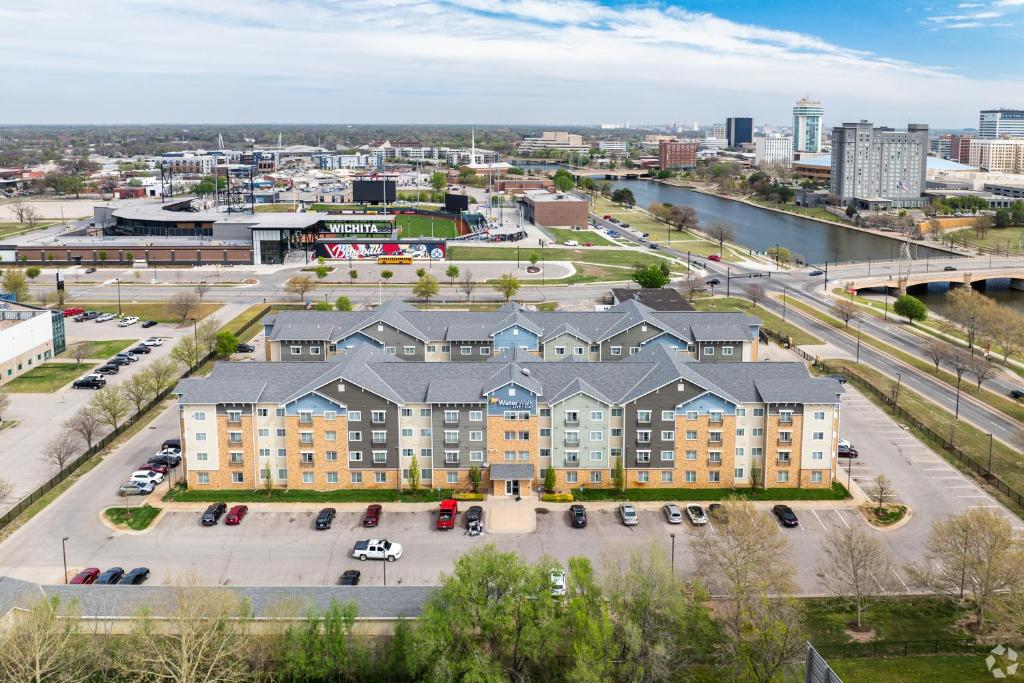 une vue aérienne sur un bâtiment avec un parking dans l'établissement WaterWalk Wichita Downtown, à Wichita