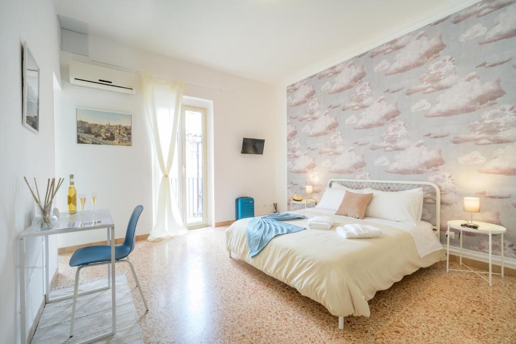 a bedroom with a bed and a wall with clouds at Casa Risìu in Ragusa