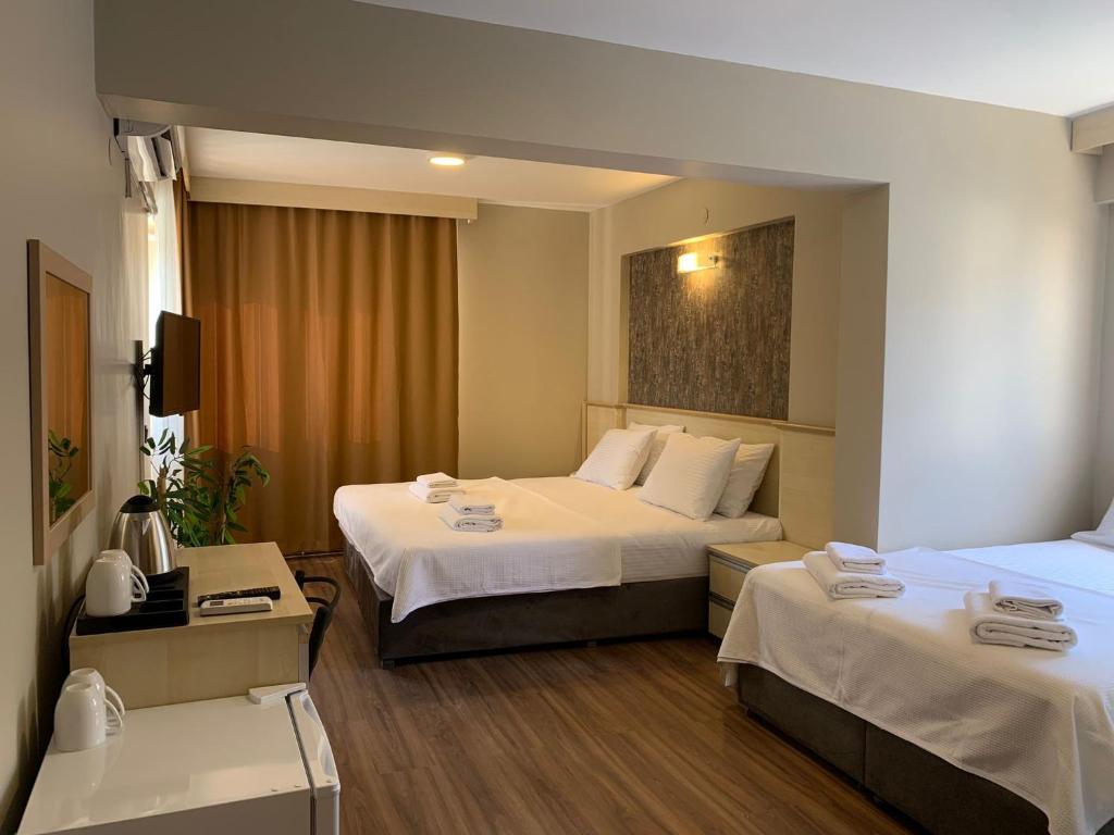 pokój hotelowy z 2 łóżkami i telewizorem w obiekcie akcayzeytin otel w mieście Akçay
