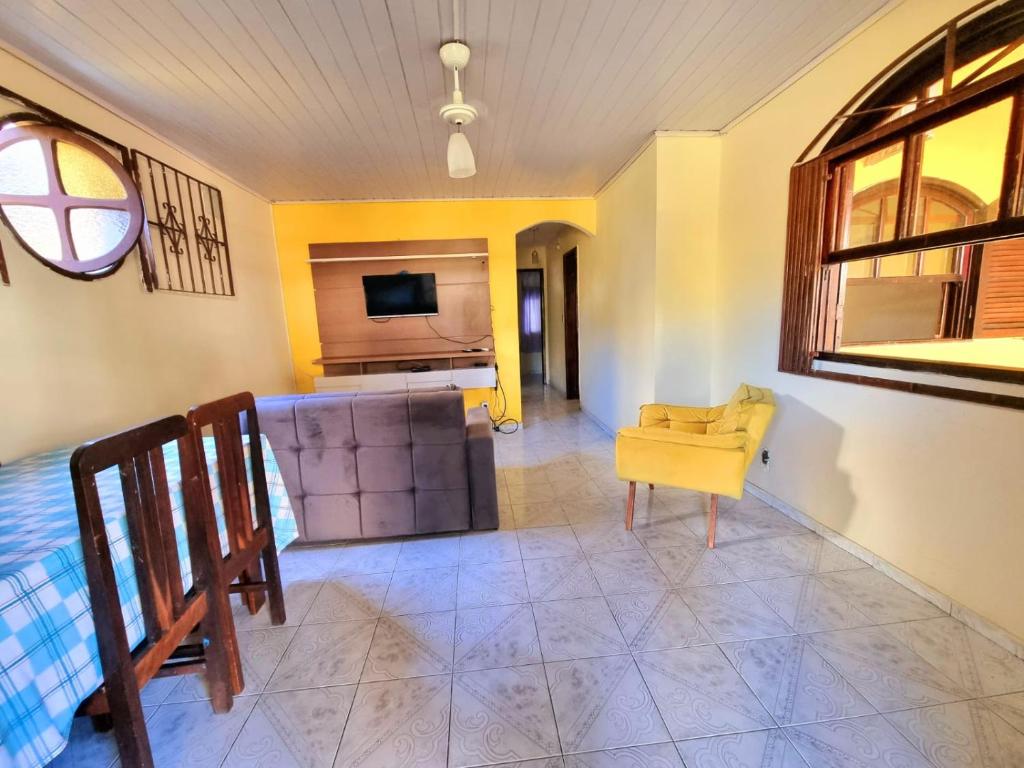 a living room with a couch and a television at Casa Praia Grande - Arraial do Cabo in Arraial do Cabo