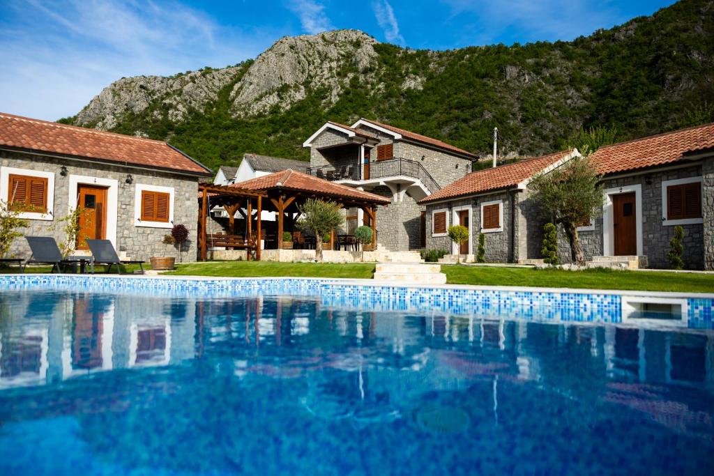 a house with a swimming pool in front of a mountain at Lake Valley in Virpazar