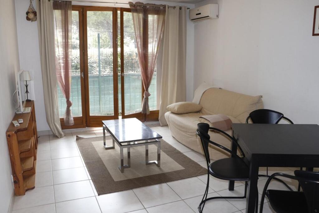 ein Wohnzimmer mit einem Sofa und einem Tisch in der Unterkunft Gionova furnished flat in Aix-en-Provence