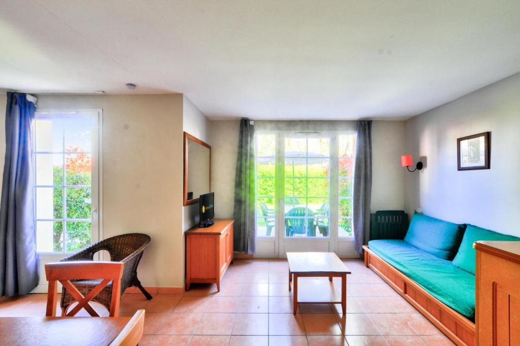 un salon avec un canapé et une table dans l'établissement La résidence du Lac - maeva Home - Maison 3 pièces 8 personnes - Sélection MAE-5594, à Monflanquin