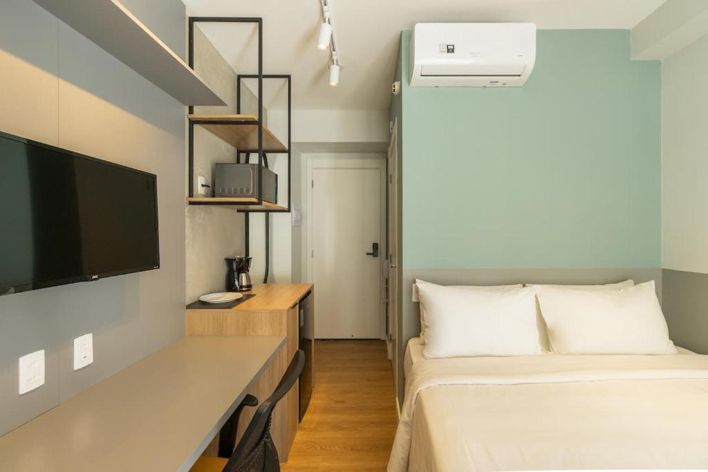 ein kleines Schlafzimmer mit einem Bett und einem TV in der Unterkunft BHomy Brooklin - Charmoso com varanda BUR108 in São Paulo