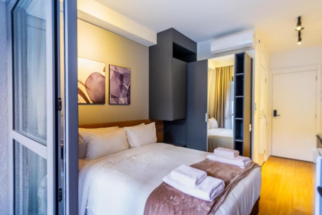 een slaapkamer met een bed met twee handdoeken erop bij BHomy Brooklin - 300m estacão da Brooklin BUR101 in Sao Paulo