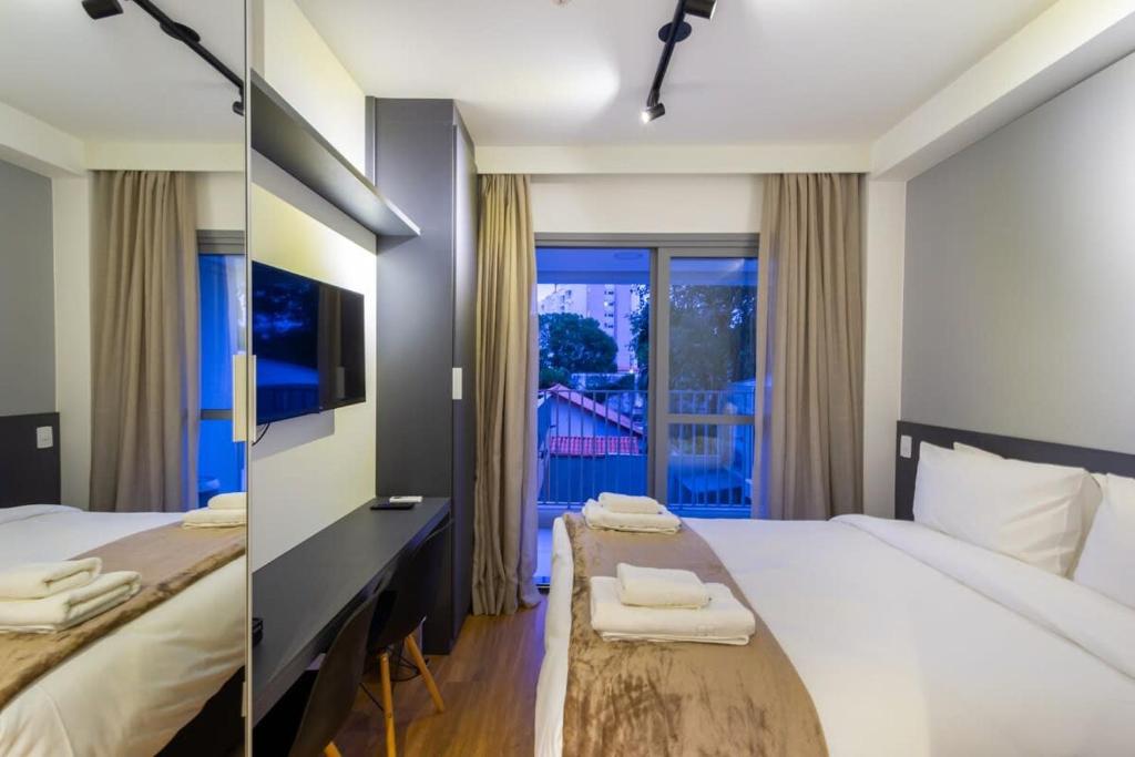 um quarto de hotel com uma cama e uma varanda em BHomy Brooklin - Com varanda espaçosa BUR205 em São Paulo