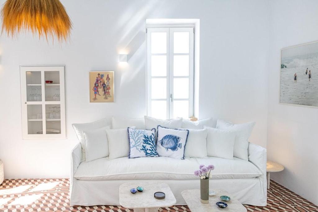 a living room with a white couch and a table at Chiara Mykonos III in Mýkonos City