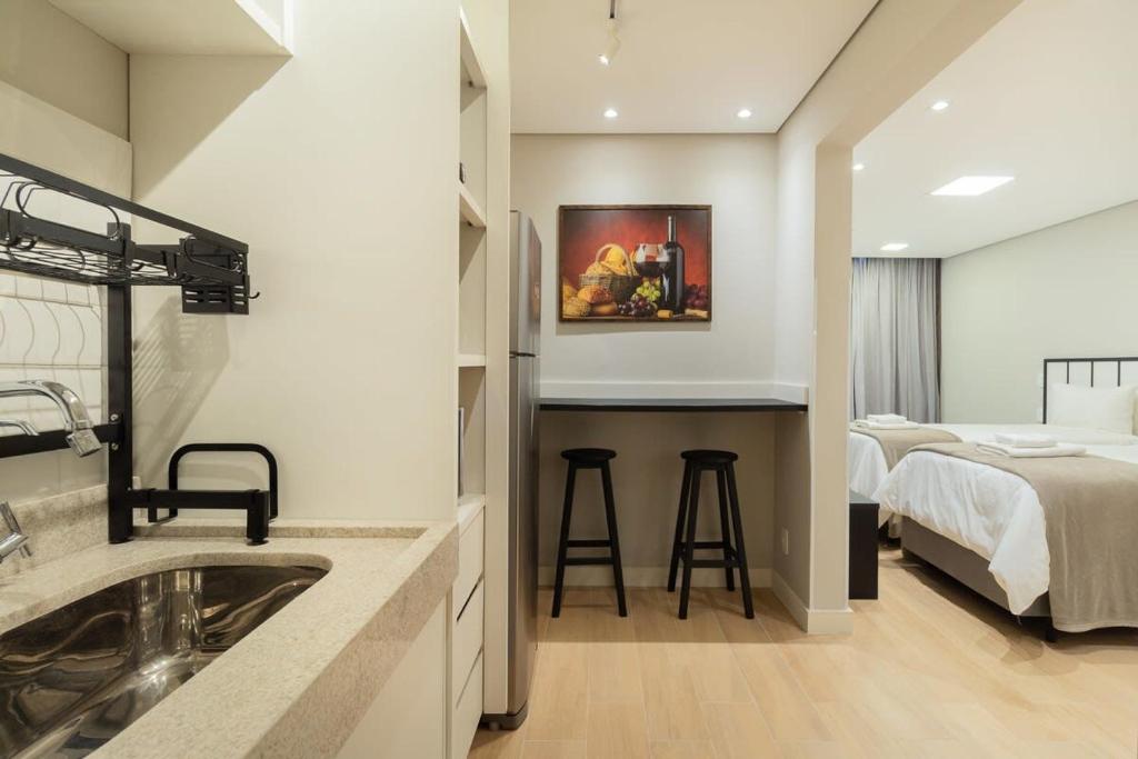 uma casa de banho com um lavatório e um quarto com uma cama em BHomy Paulista - Perfeita localizacao MR173 em São Paulo