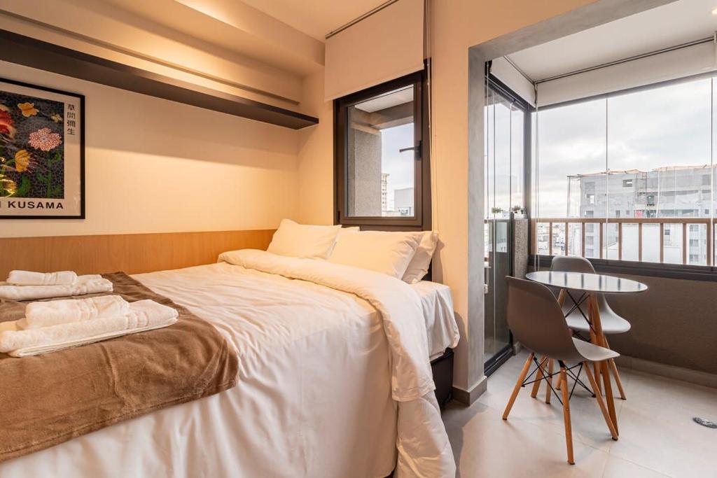 um quarto com uma cama, uma mesa e uma janela em B Homy Paulista - 270m do Trianon Masp PLO1406 em São Paulo