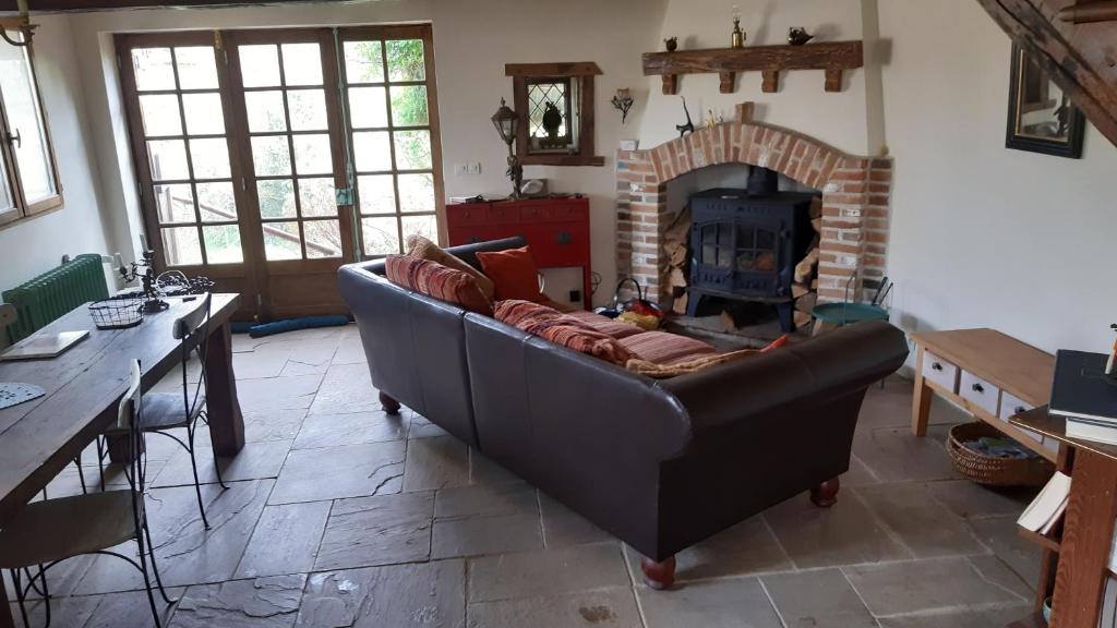 a living room with a couch and a fireplace at Au coeur des loges in Saint-Bonnet-de-Bellac