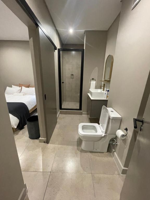 La salle de bains est pourvue de toilettes, d'un lavabo et d'un lit. dans l'établissement On Fredman Drive, à Johannesbourg