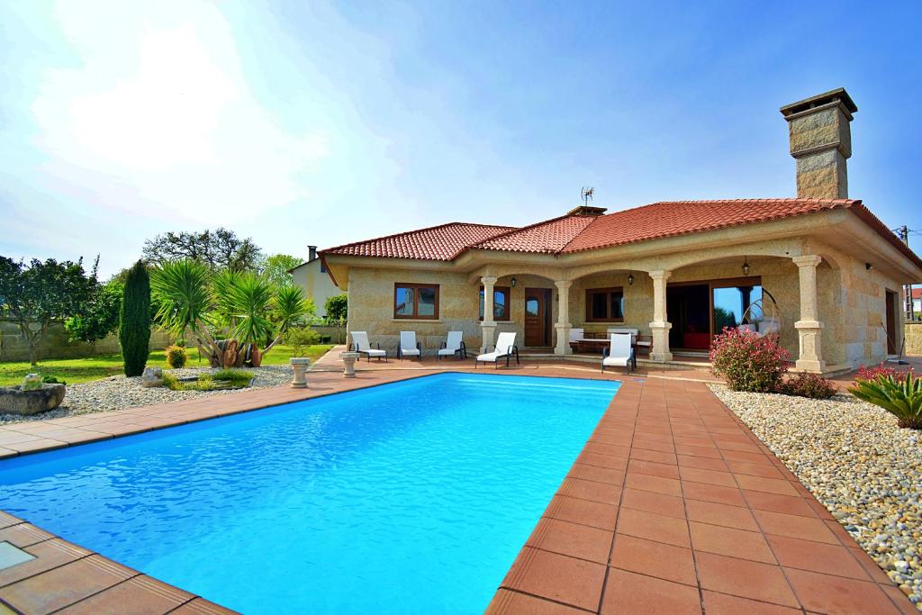 una casa con piscina frente a una casa en Villa con piscina en Cambados, en Cambados