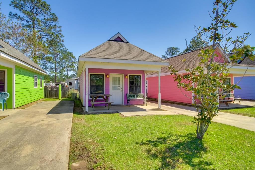 una casa colorida con porche en un patio en Biloxi Resort Cottage with Pool and Lake Access!, en Biloxi