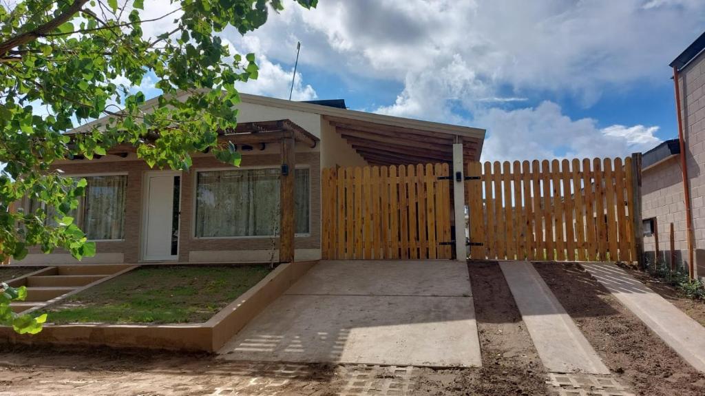 una pequeña casa con una valla de madera en Colorina - El Nihuil en El Nihuil