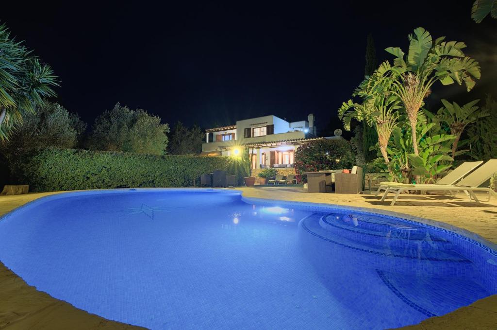 una grande piscina blu di fronte a una casa di Can Juanito a Playa d'en Bossa