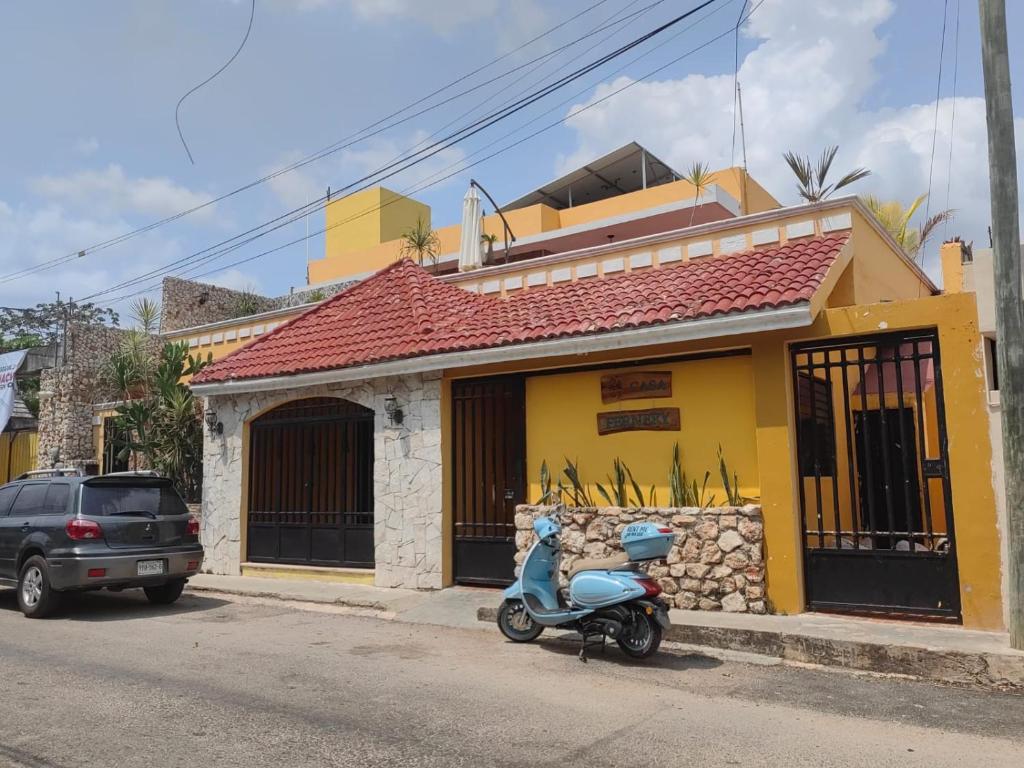 a scooter parked in front of a yellow building at Casa Fernery in Valladolid