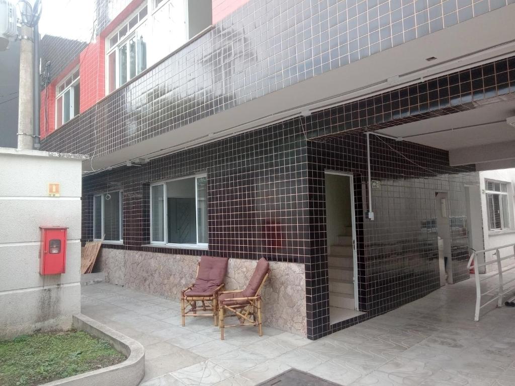 twee stoelen op een patio buiten een gebouw bij Aloha Hostel&CoWorking - Prox Aeroporto e Consulado in Porto Alegre