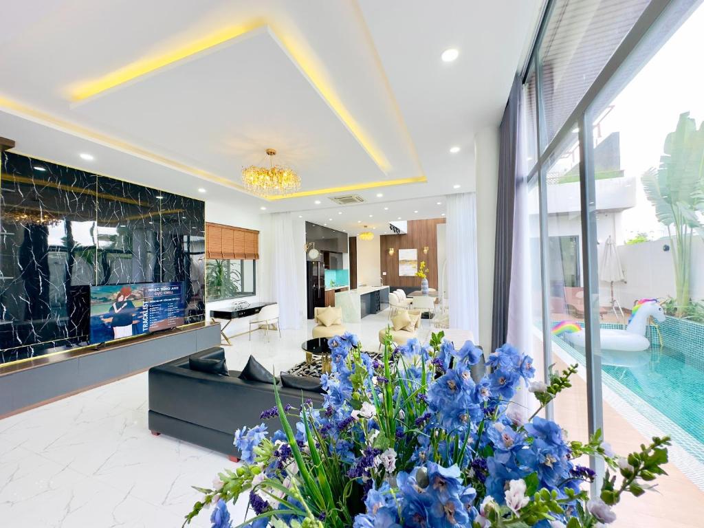 a living room with a swimming pool and blue flowers at Private 5Brs Pool Villa Luxurious Furniture in Danang