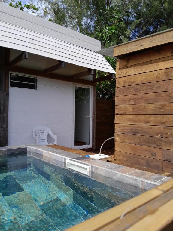 uma piscina em frente a uma casa em Mara'ai le spot Tubuai, Chambre Triple Deluxe Mahu SDB Privée avec piscine em Tubuai