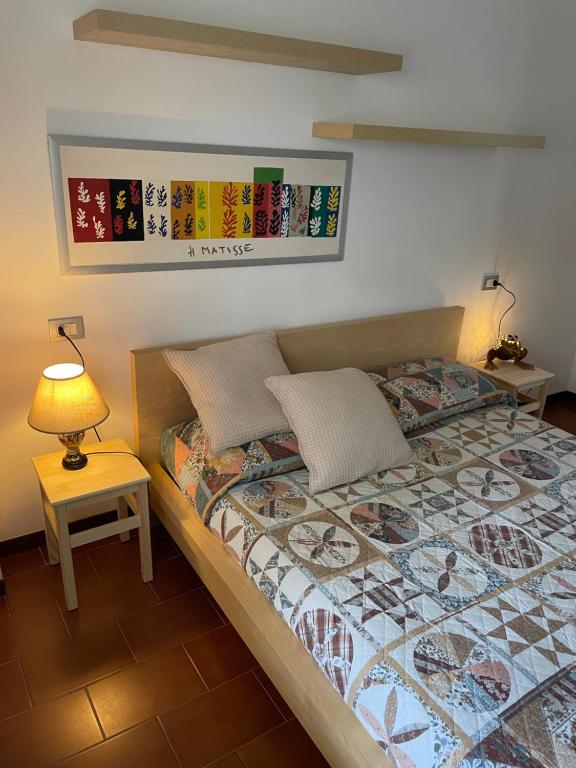 a bedroom with a bed and a lamp on a table at Appartamento Gaia - a due passi dal centro in Laveno-Mombello
