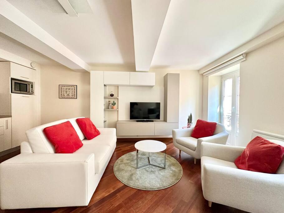 - un salon avec deux canapés blancs et des oreillers rouges dans l'établissement Rose 3-Plage- climatisation, à Menton