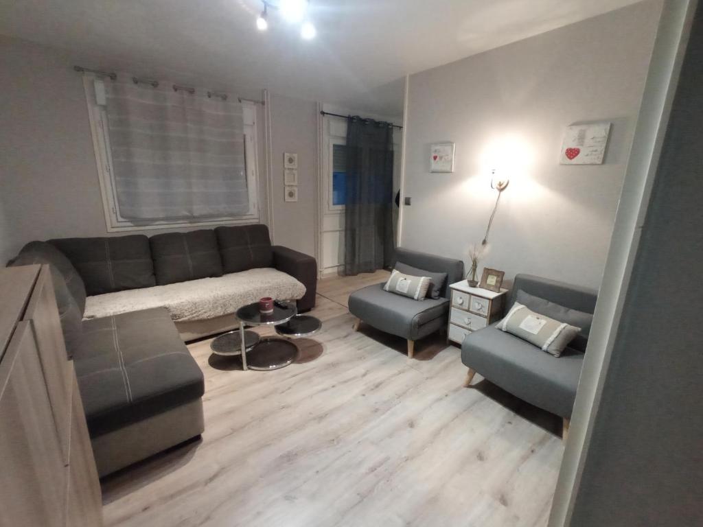 a living room with a couch and two chairs at Studio cosy à 10 minutes du centre-ville. in Saint-Étienne