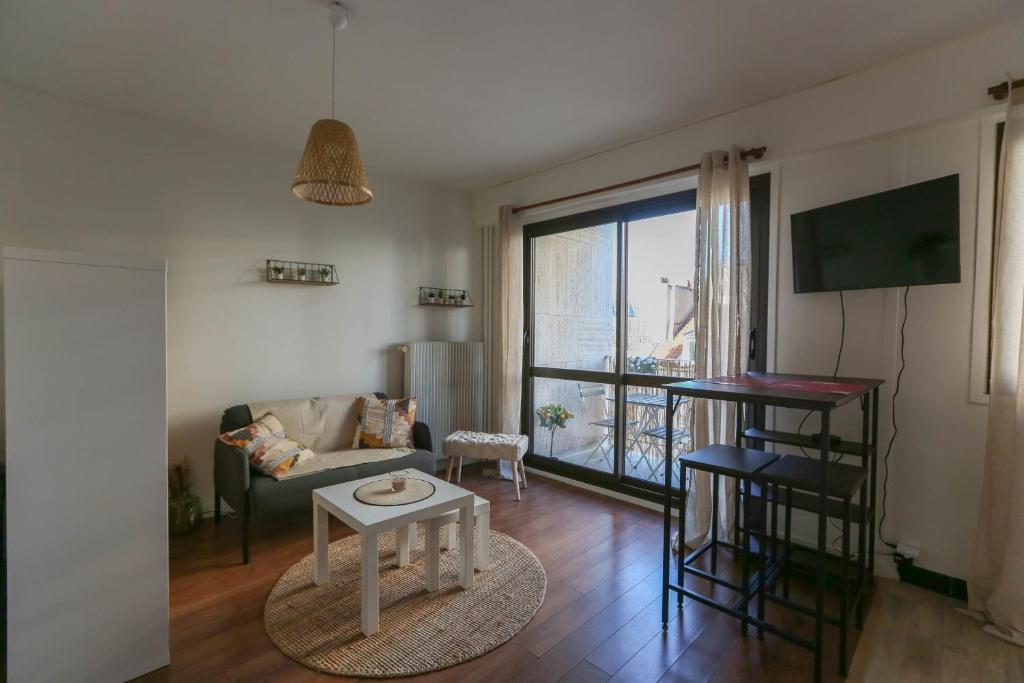 a living room with a couch and a table at 32 m love nest studio with balcony in Paris