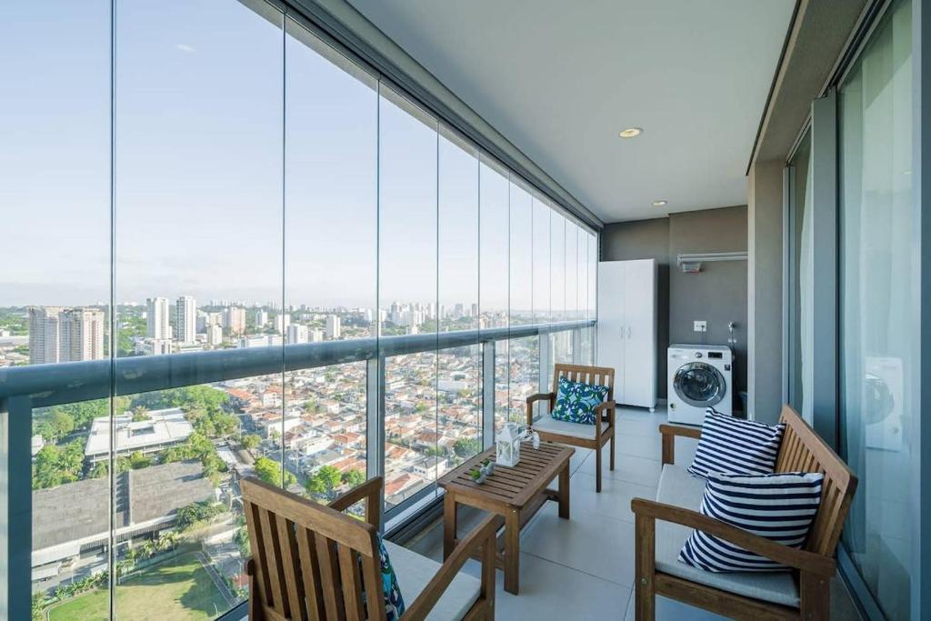 a balcony with chairs and tables and large windows at BHomy Brooklin Perto Morumbi Shopping PSP2710 in São Paulo